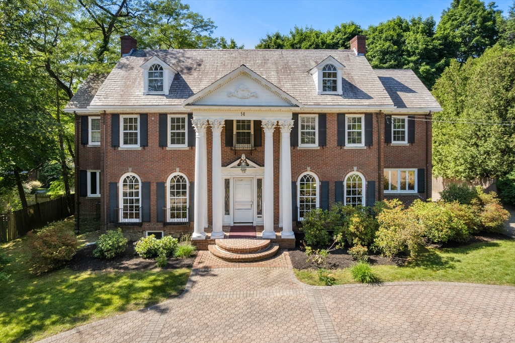 a front view of a house with yard and green space