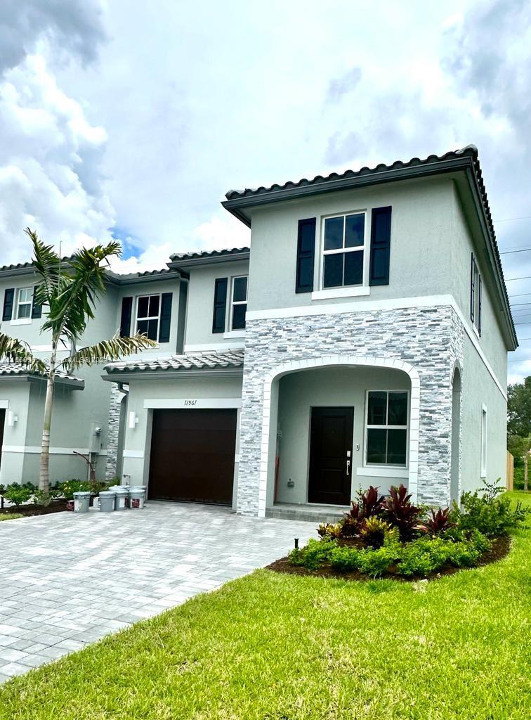 a front view of a house with a garden and yard