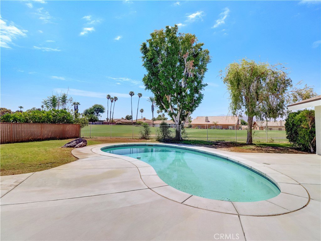 a view of a swimming pool and trees in the background