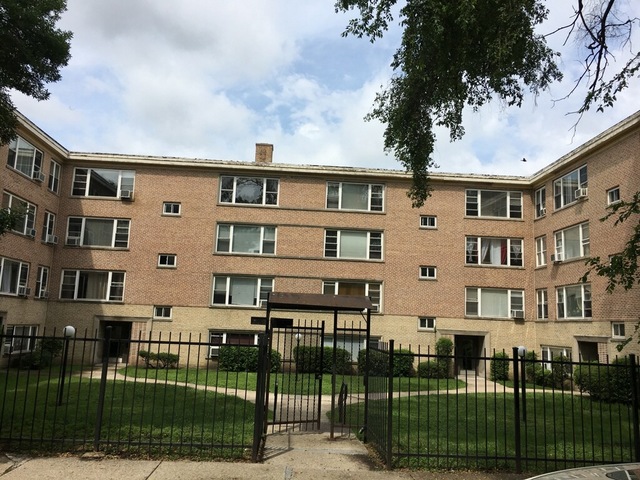 a front view of a building with glass windows and yard