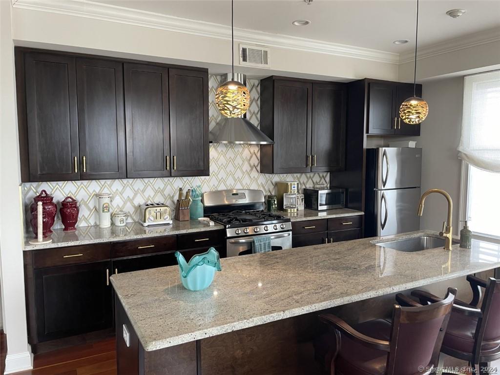 a kitchen with granite countertop stainless steel appliances and wooden cabinets