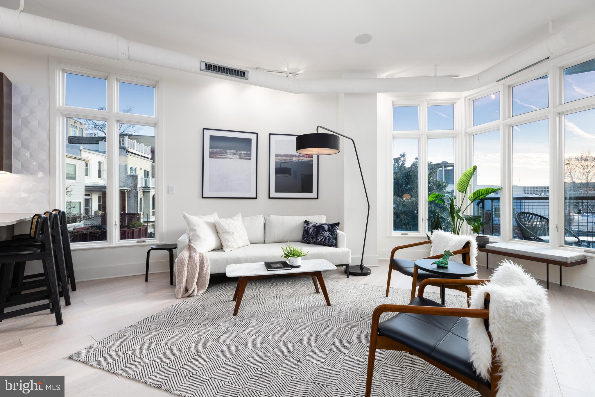 a living room with furniture potted plant and a large window