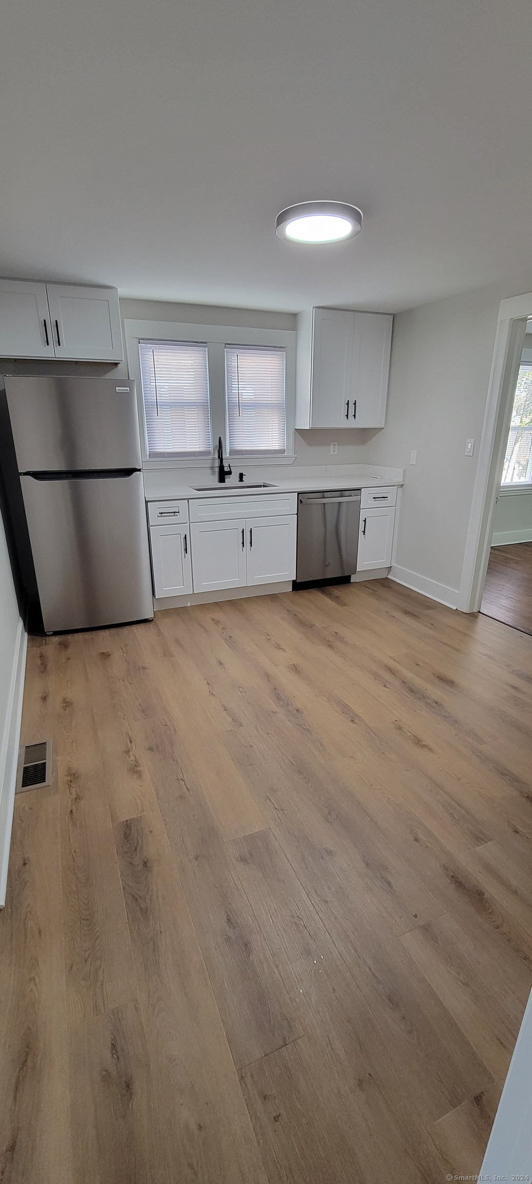 a view of a kitchen with a sink and a refrigerator