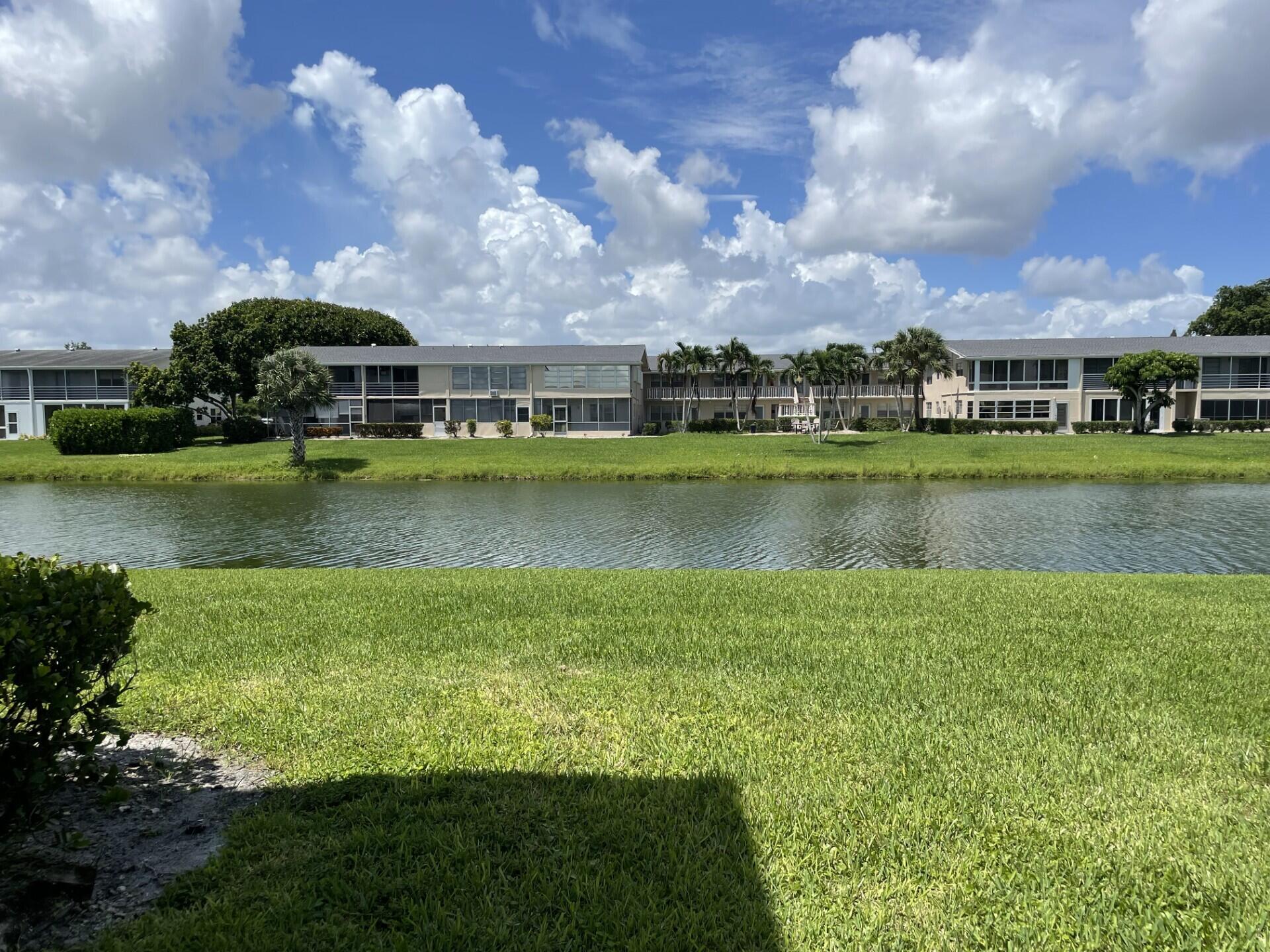 a view of a big house with a big yard and a large pool table and chairs