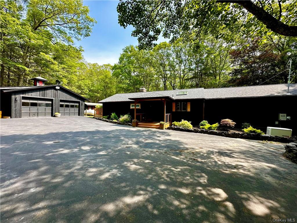 a view of a house with a yard and a tree