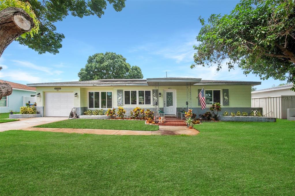 a front view of a house with a garden and patio