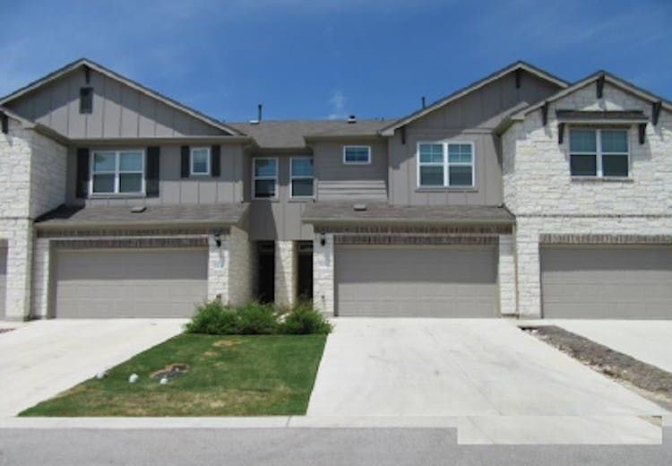 a front view of a house with a garden and garage