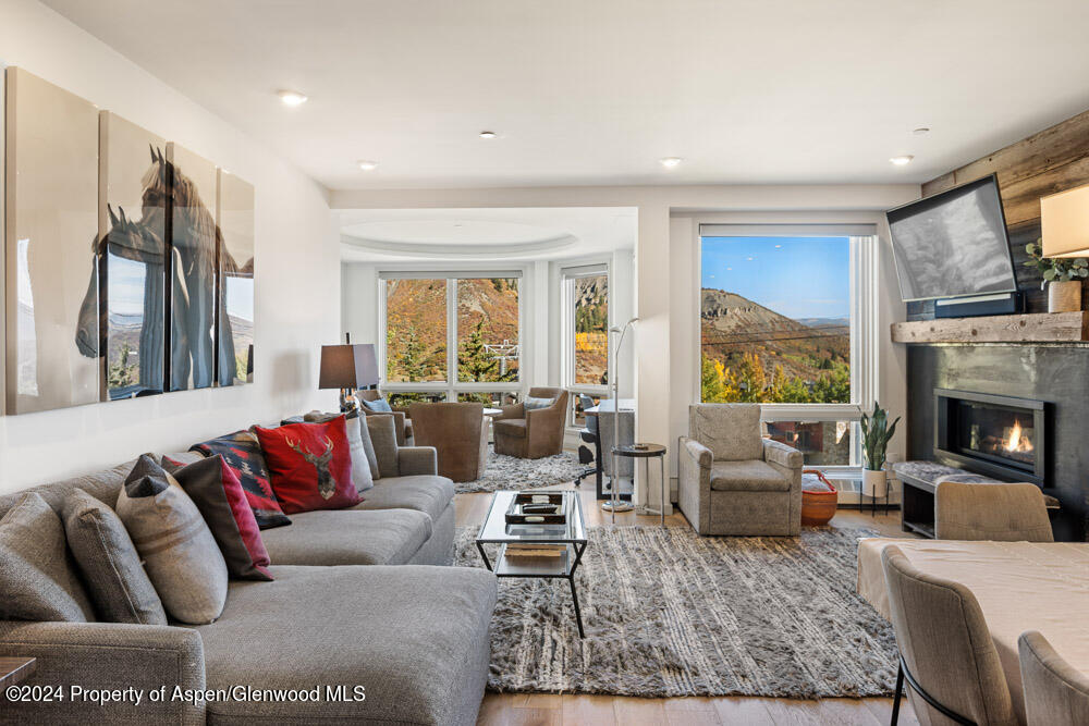 a living room with furniture fireplace and a large window