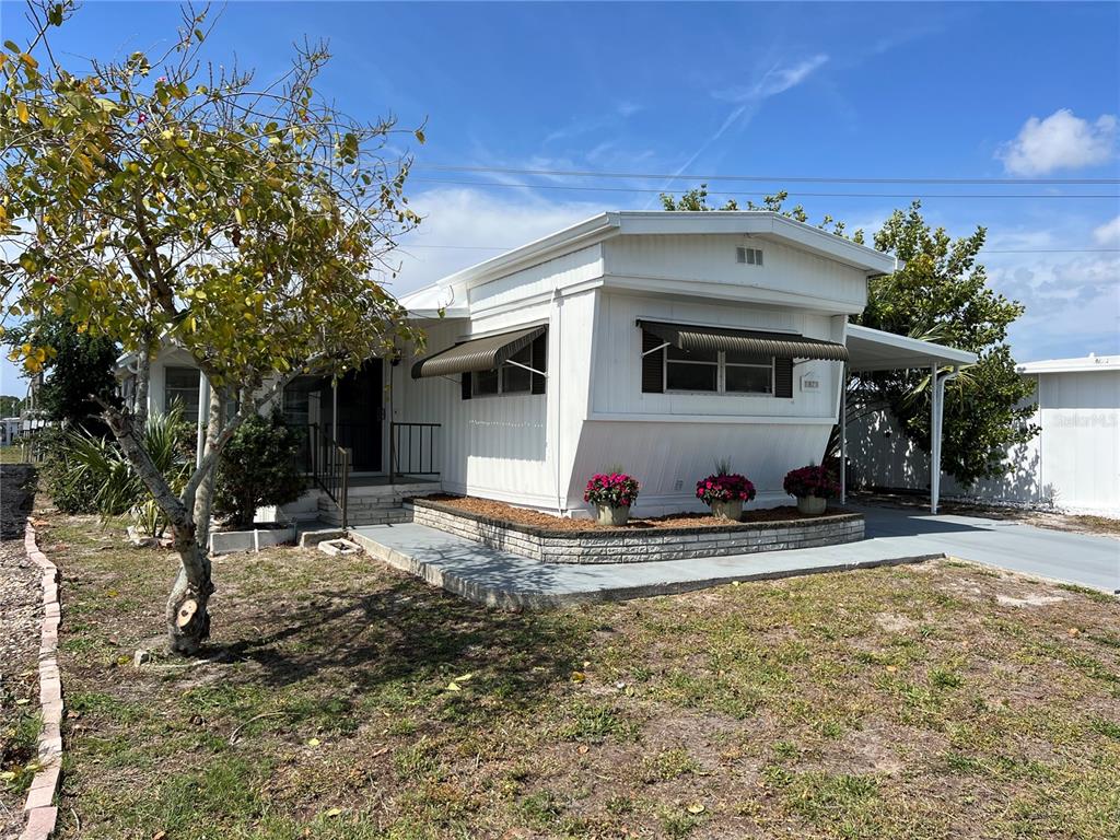 a view of a house with backyard and sitting area