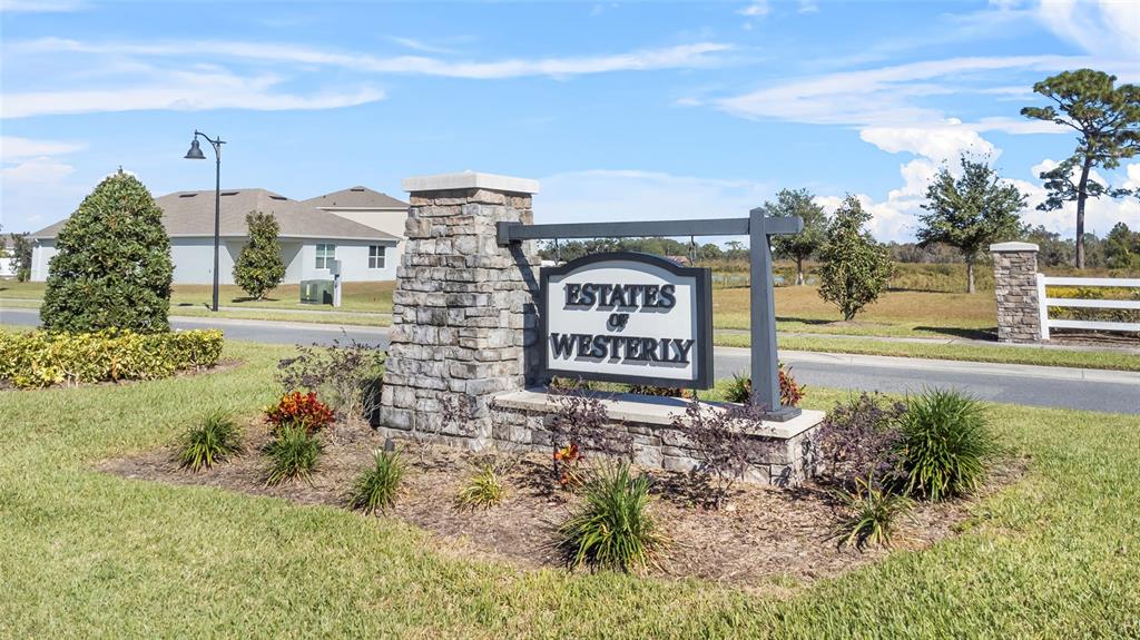 a sign board with buildings in the background