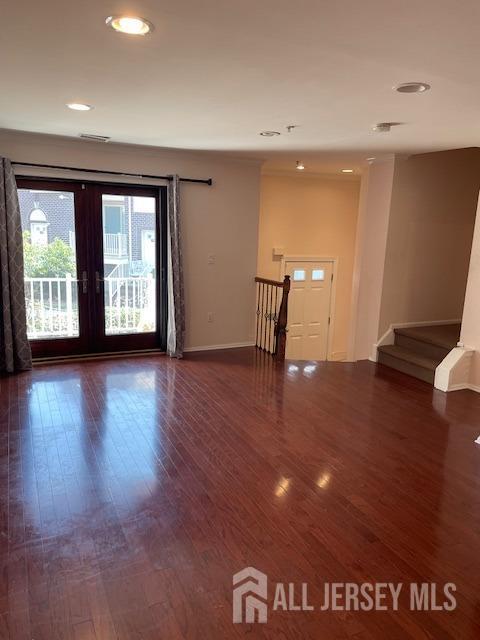 a view of an empty room with window and wooden floor