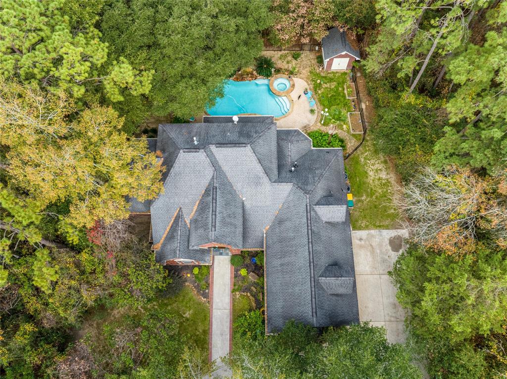 an aerial view of a house with a yard and large tree