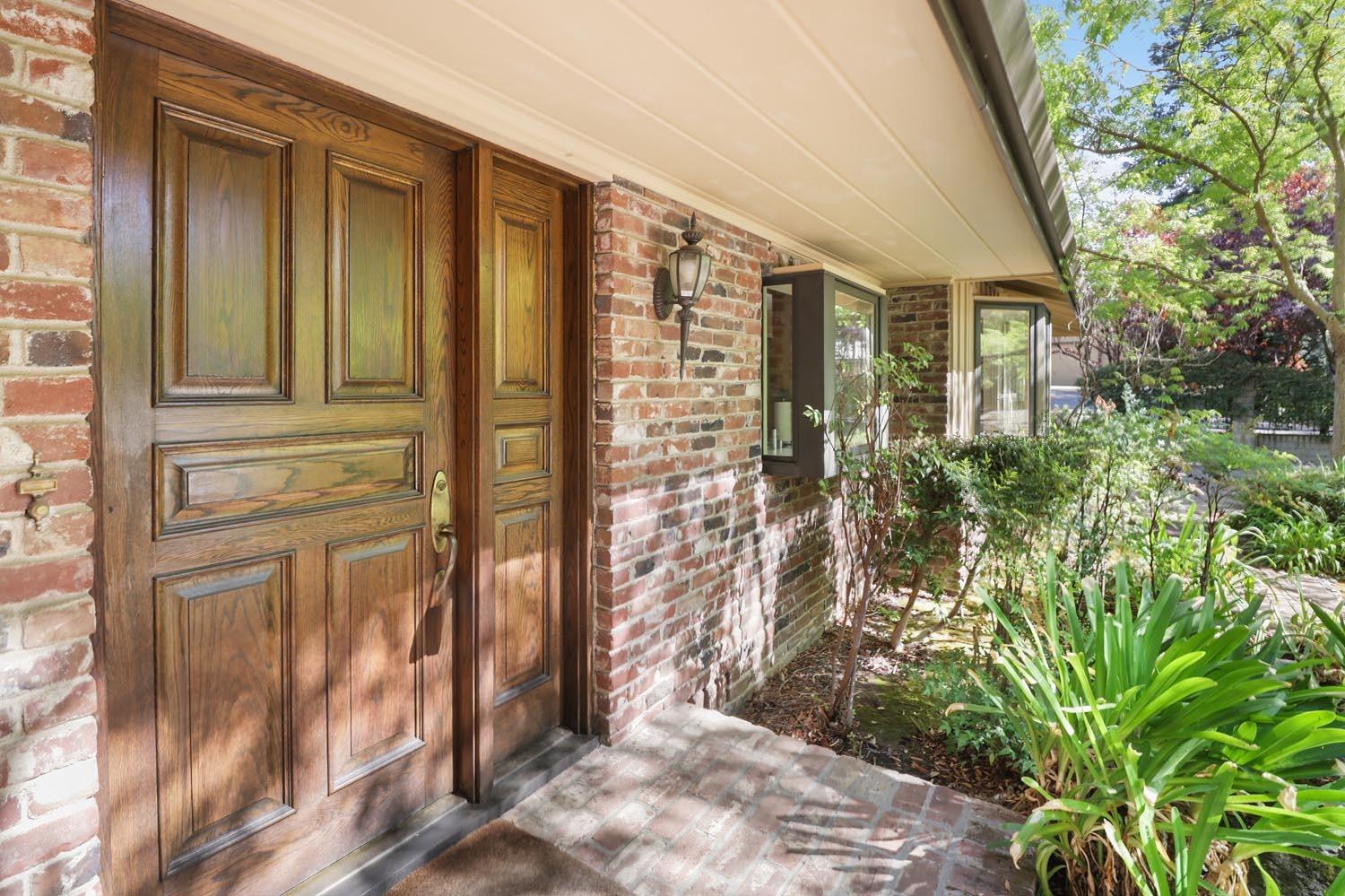 a view of a brick house with a large window and plants