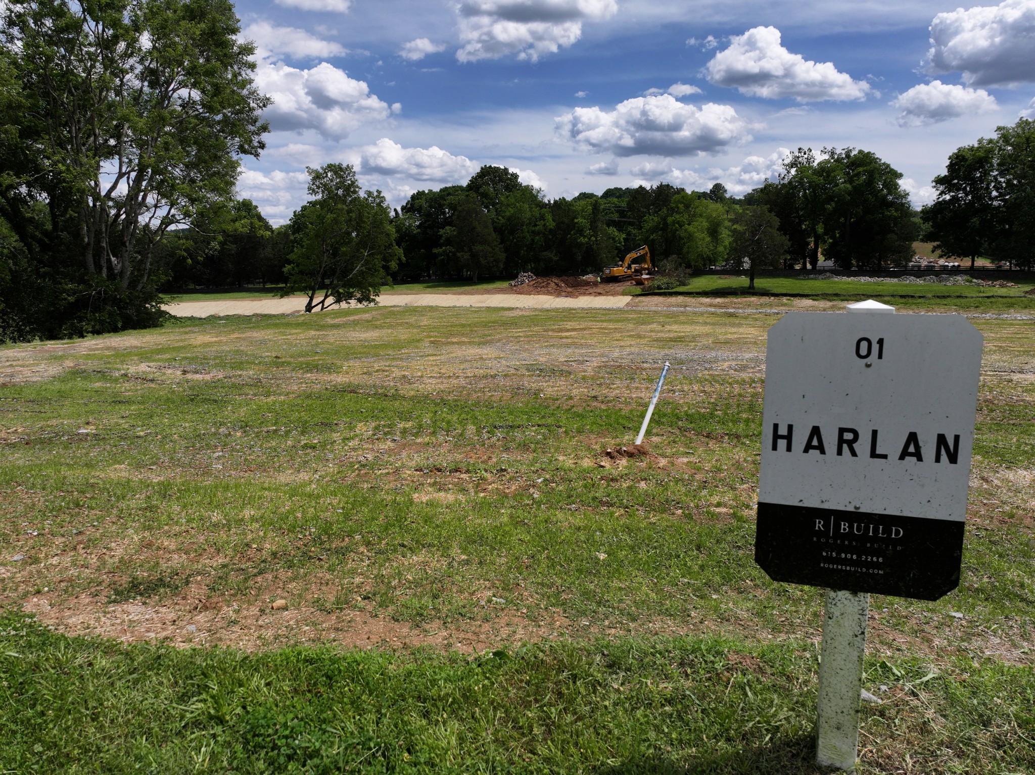 a sign board with a play ground in the back