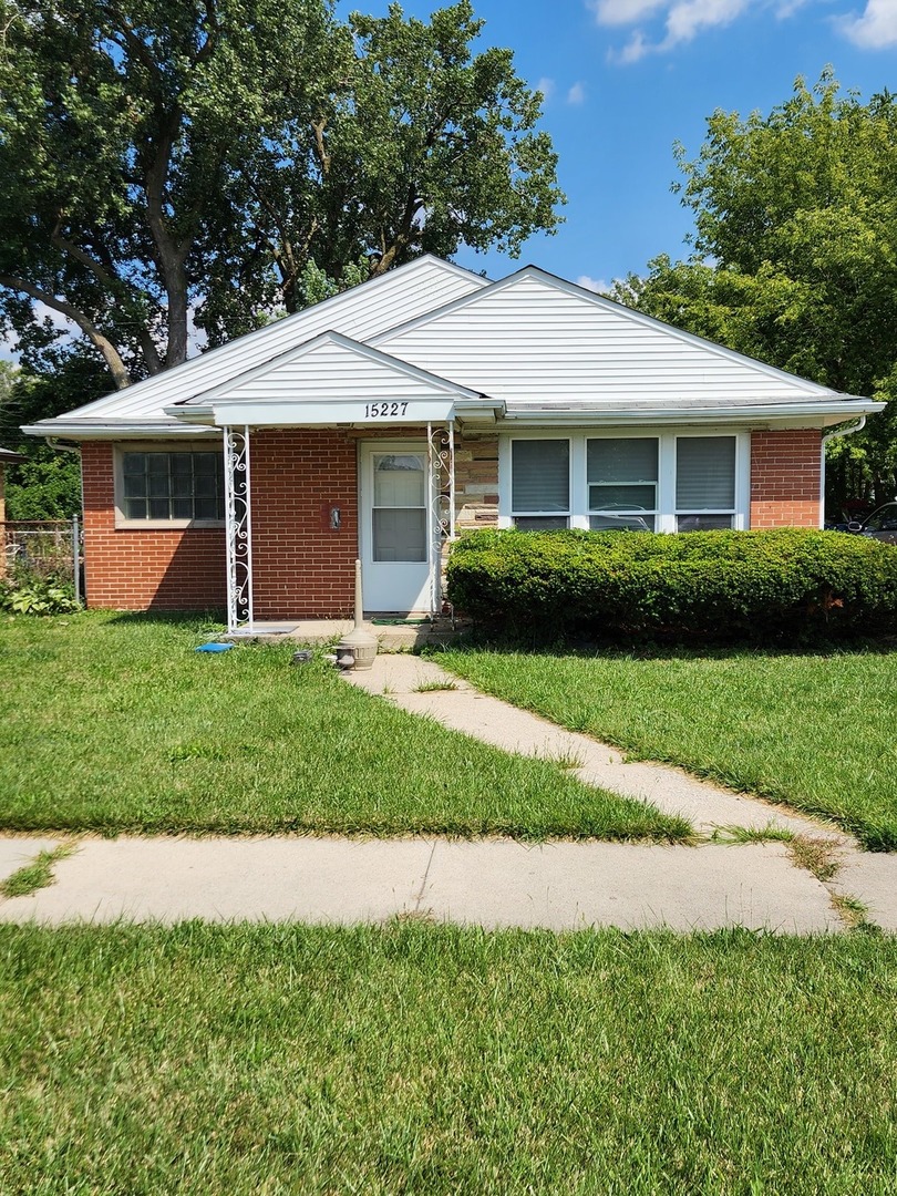 a front view of a house with a yard and green space