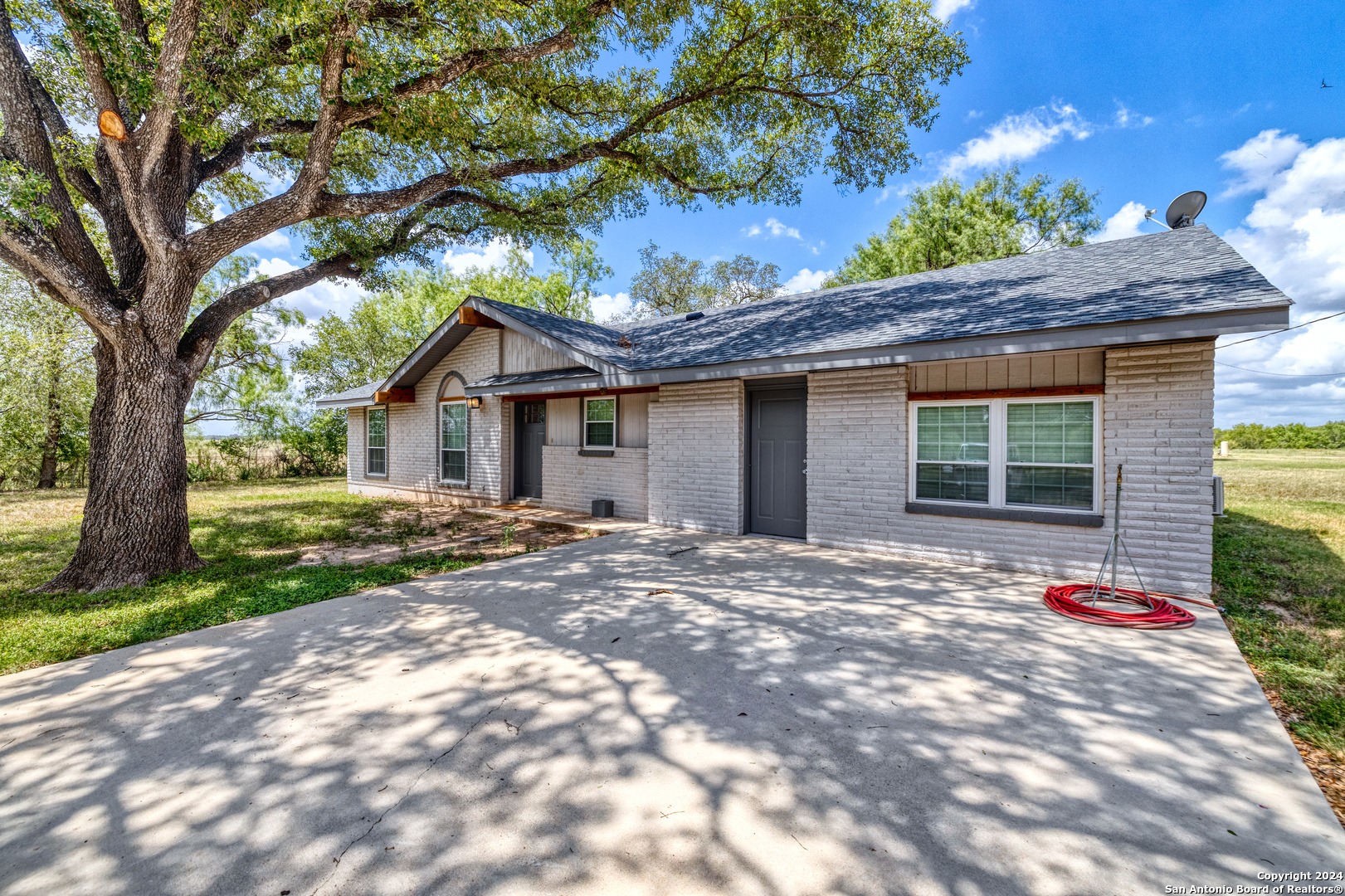 a view of a house with a tree in front of it