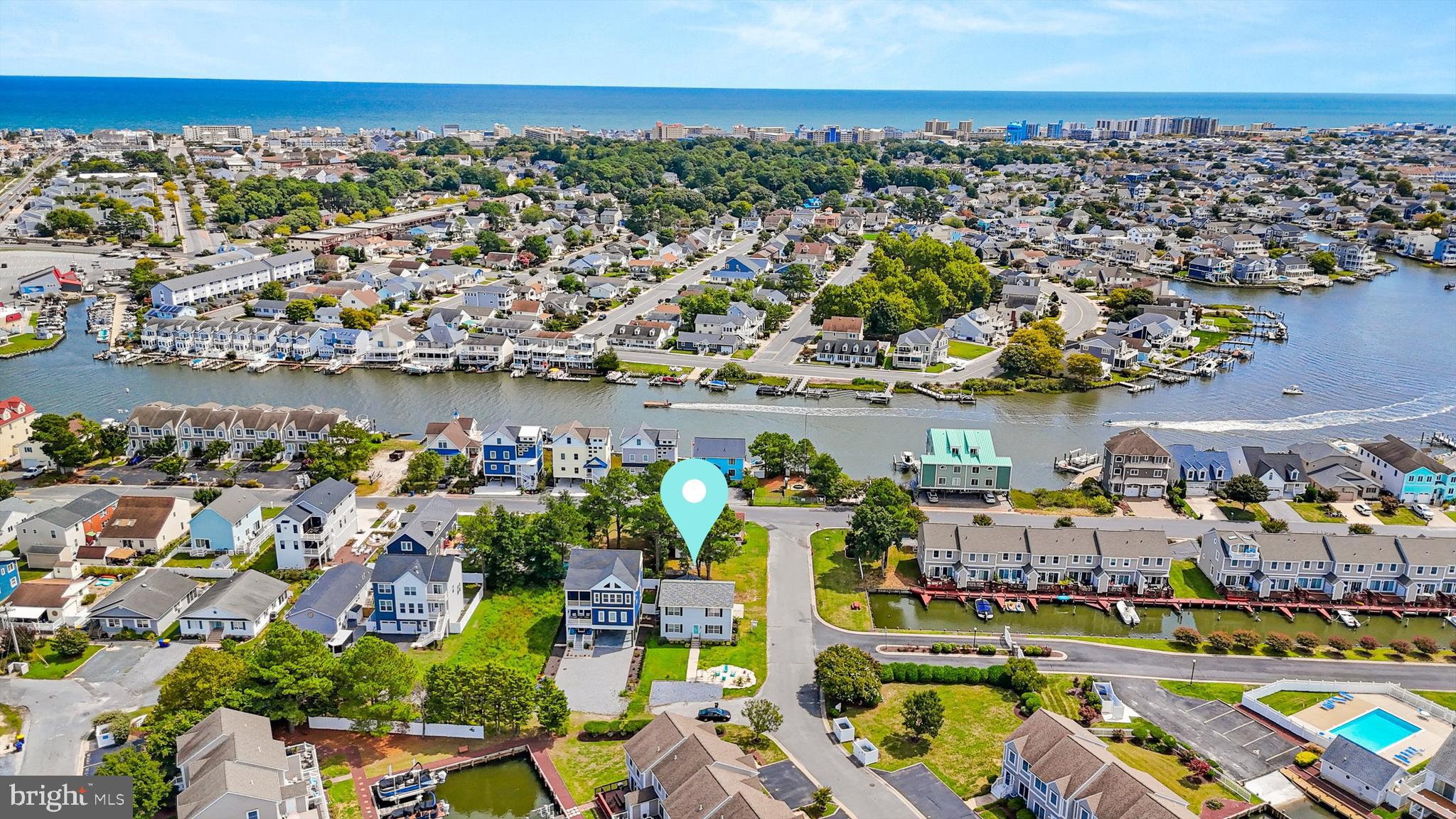 an aerial view of a city with lots of residential buildings ocean and mountain view in back