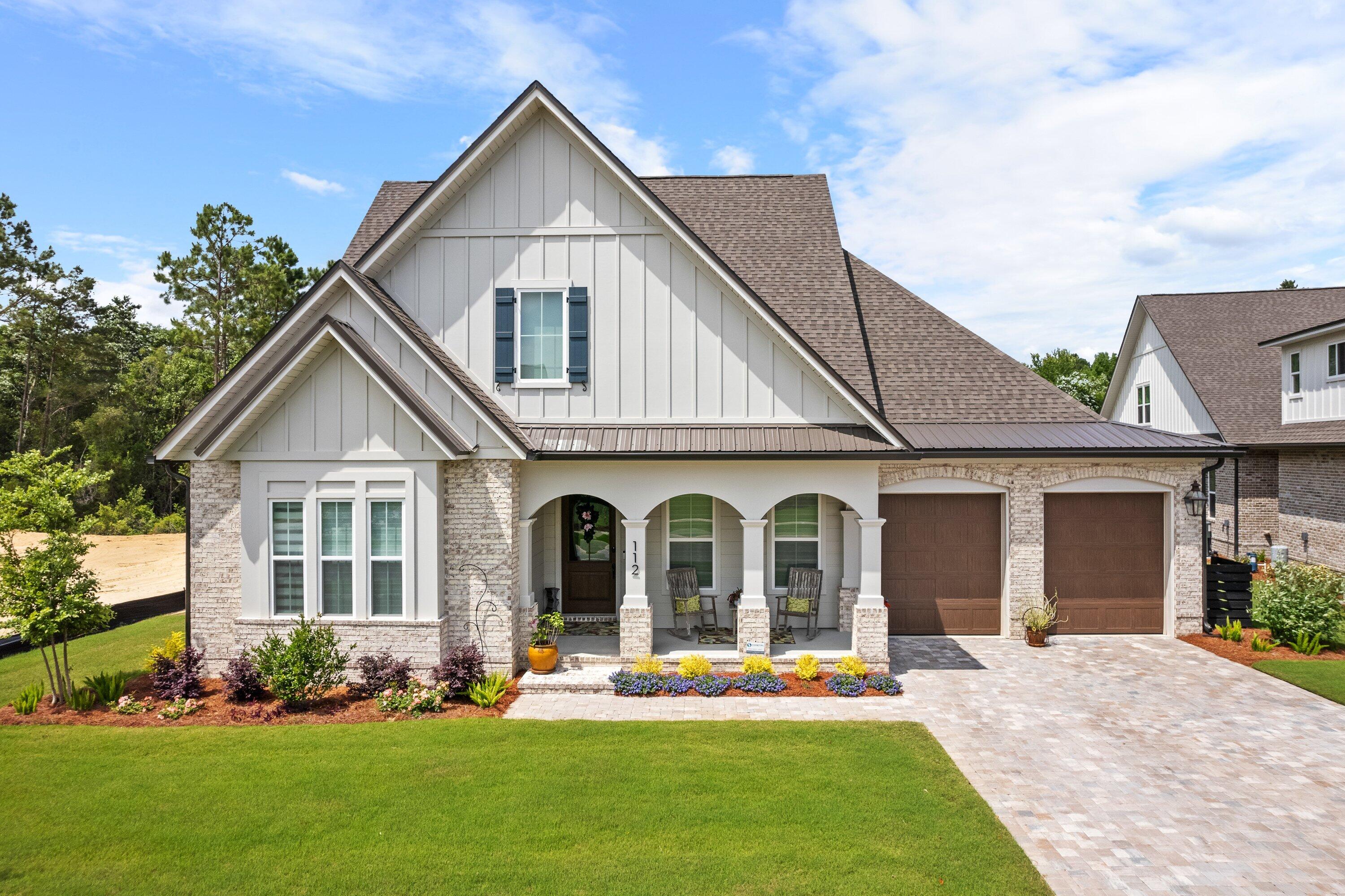 a front view of a house with a yard and trees