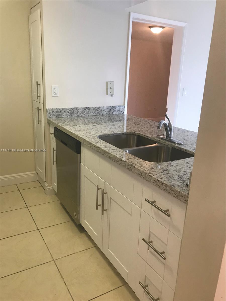 a kitchen with granite countertop a sink and a mirror