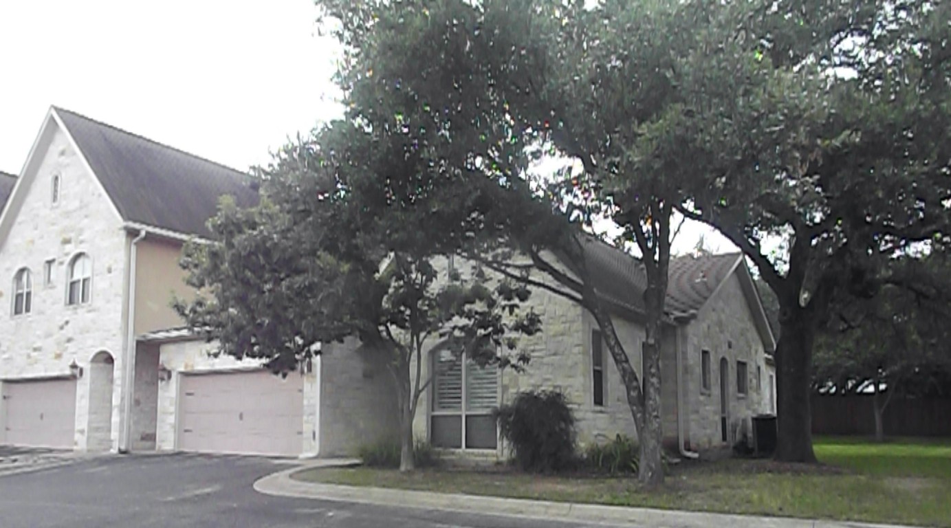 a front view of a house with a tree