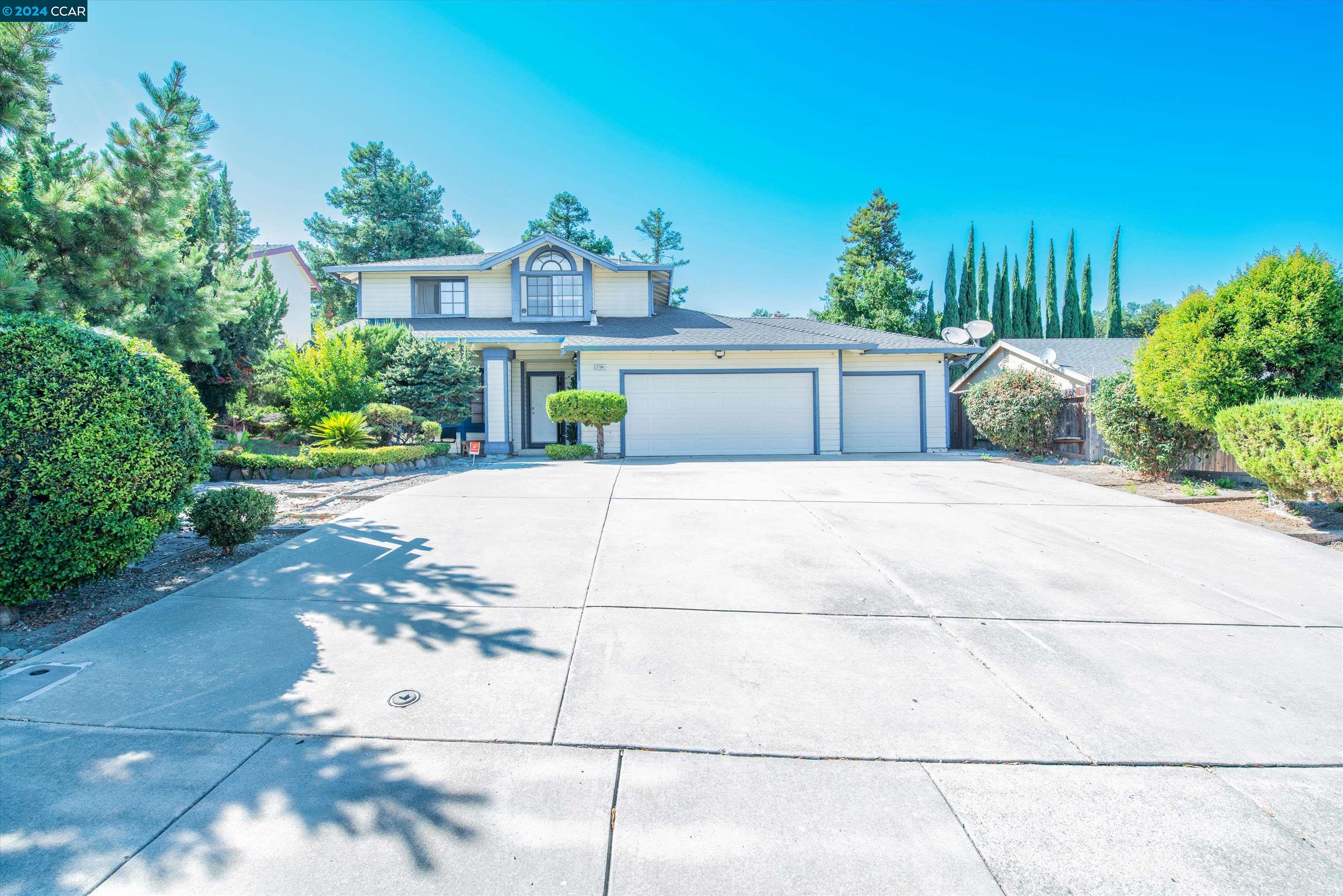 a view of a house with a yard and potted plants