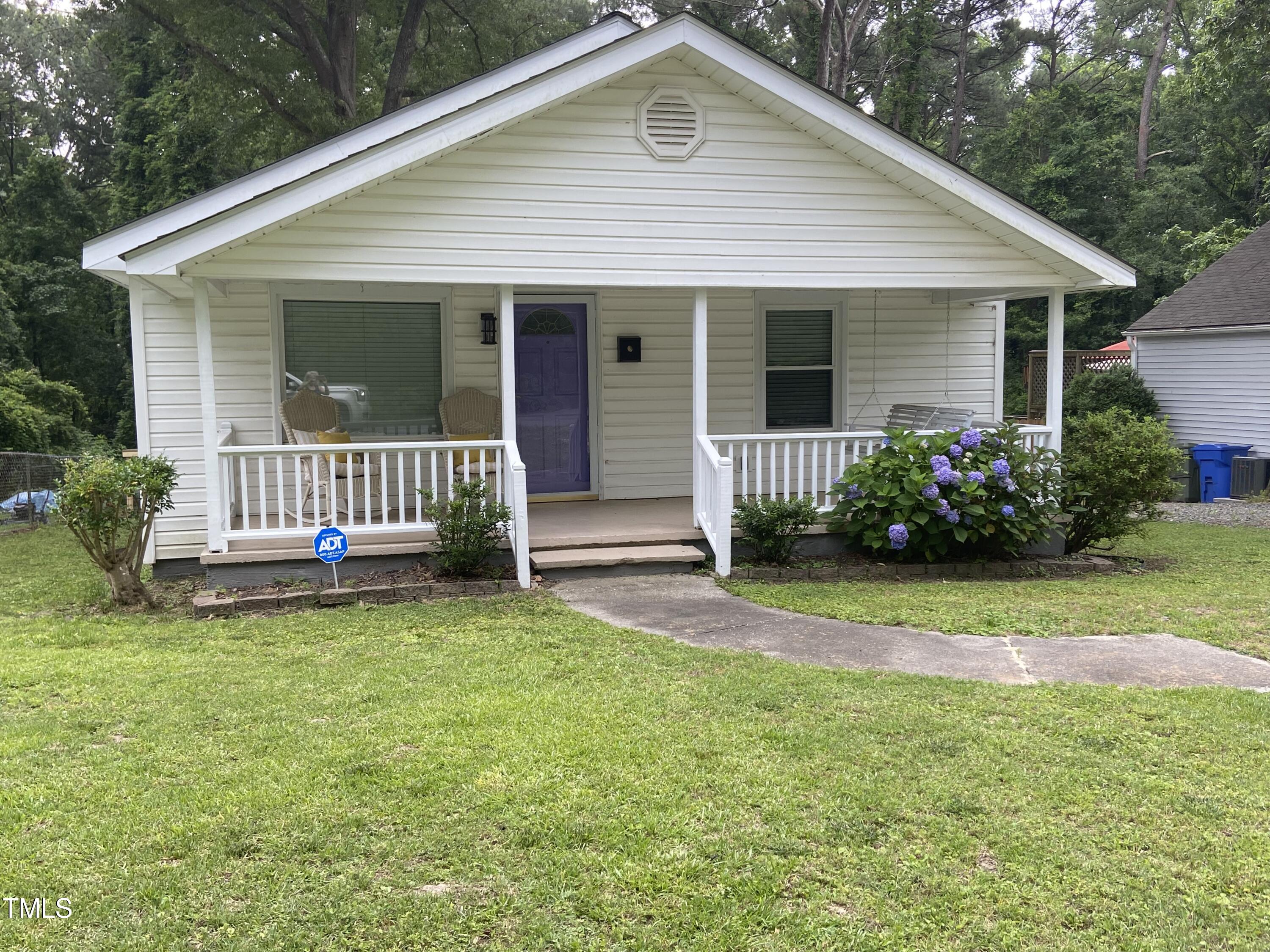 a front view of a house with a garden and yard