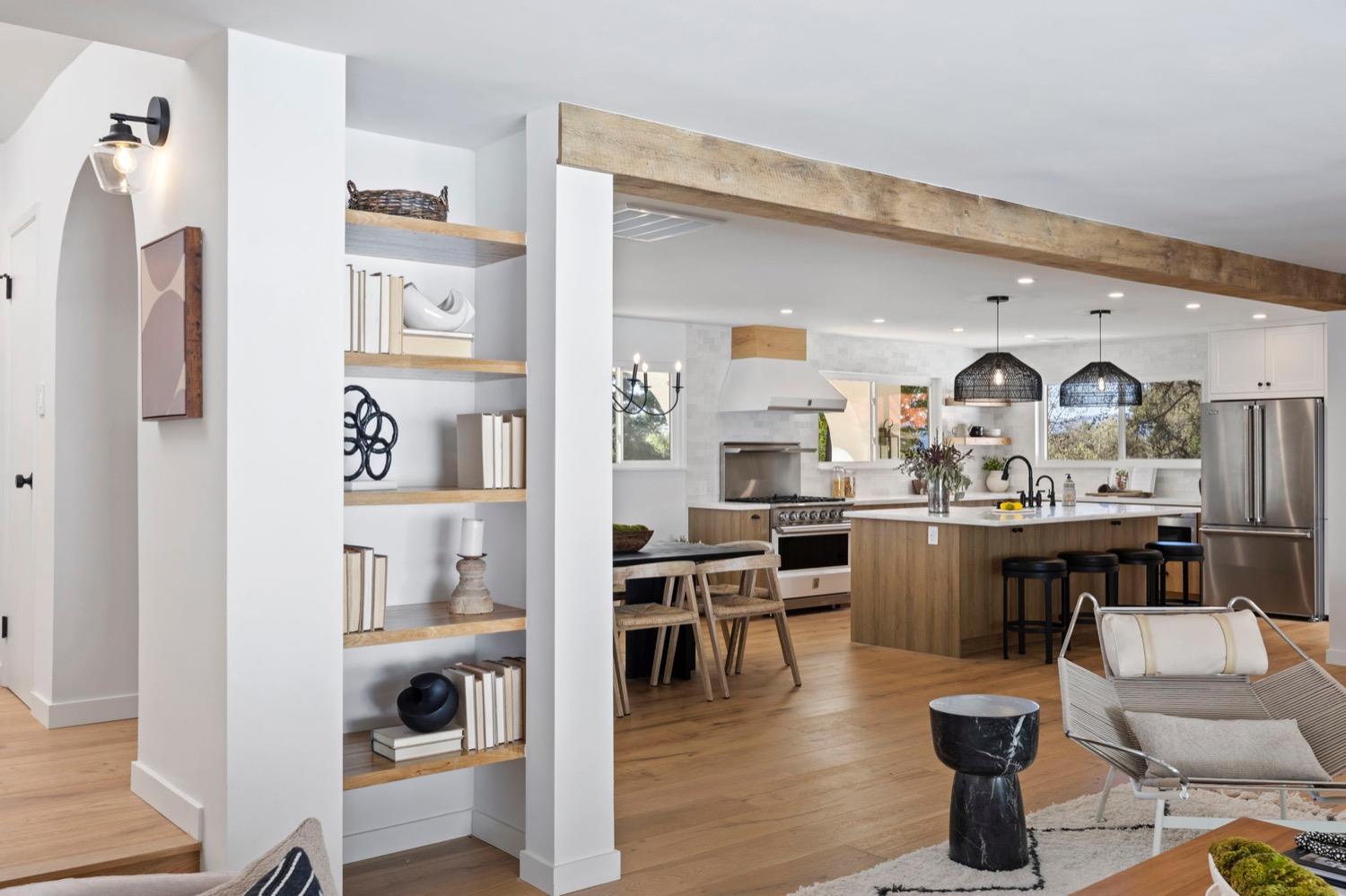 a living room with furniture a rug and kitchen view