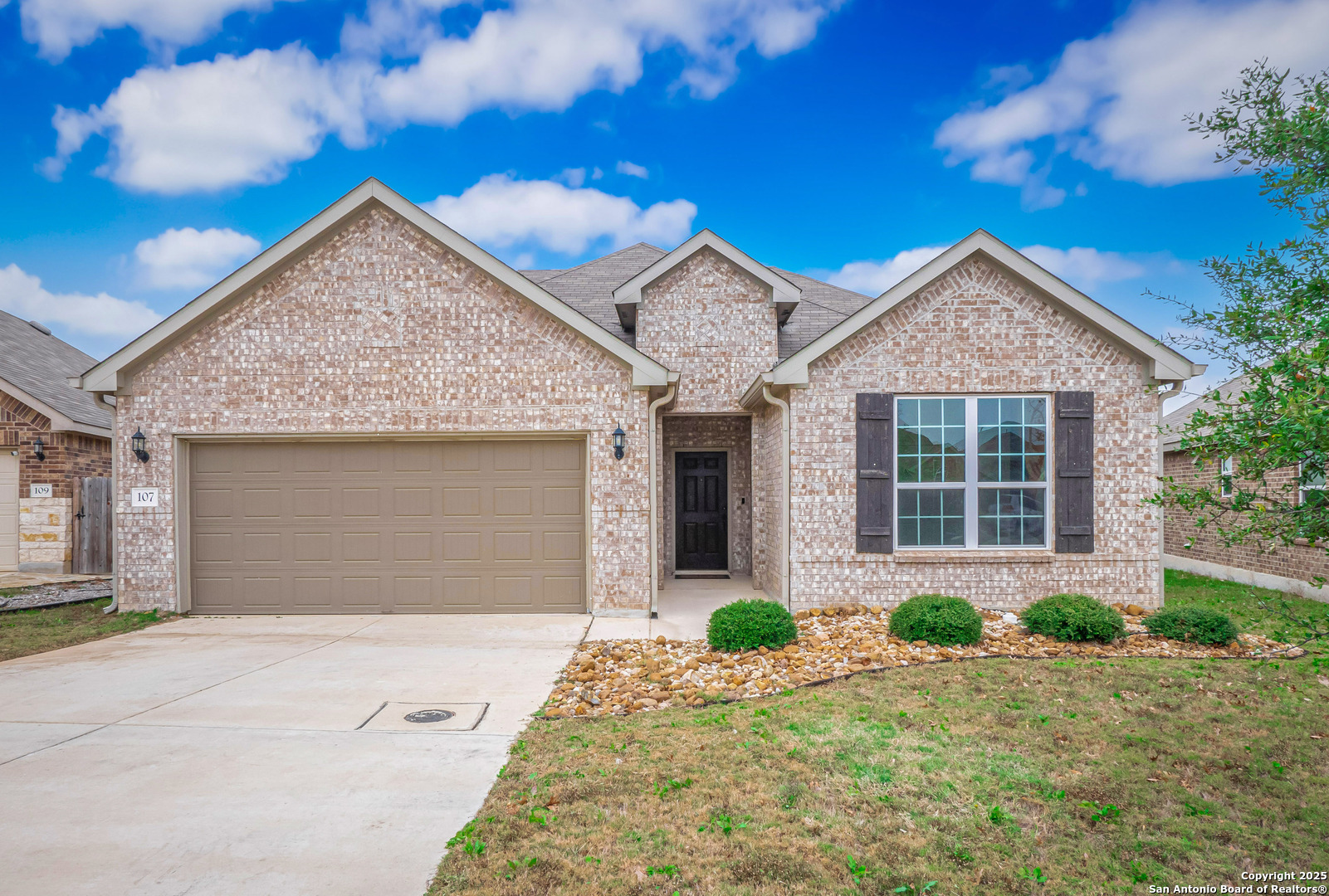 a front view of a house with a yard and garage