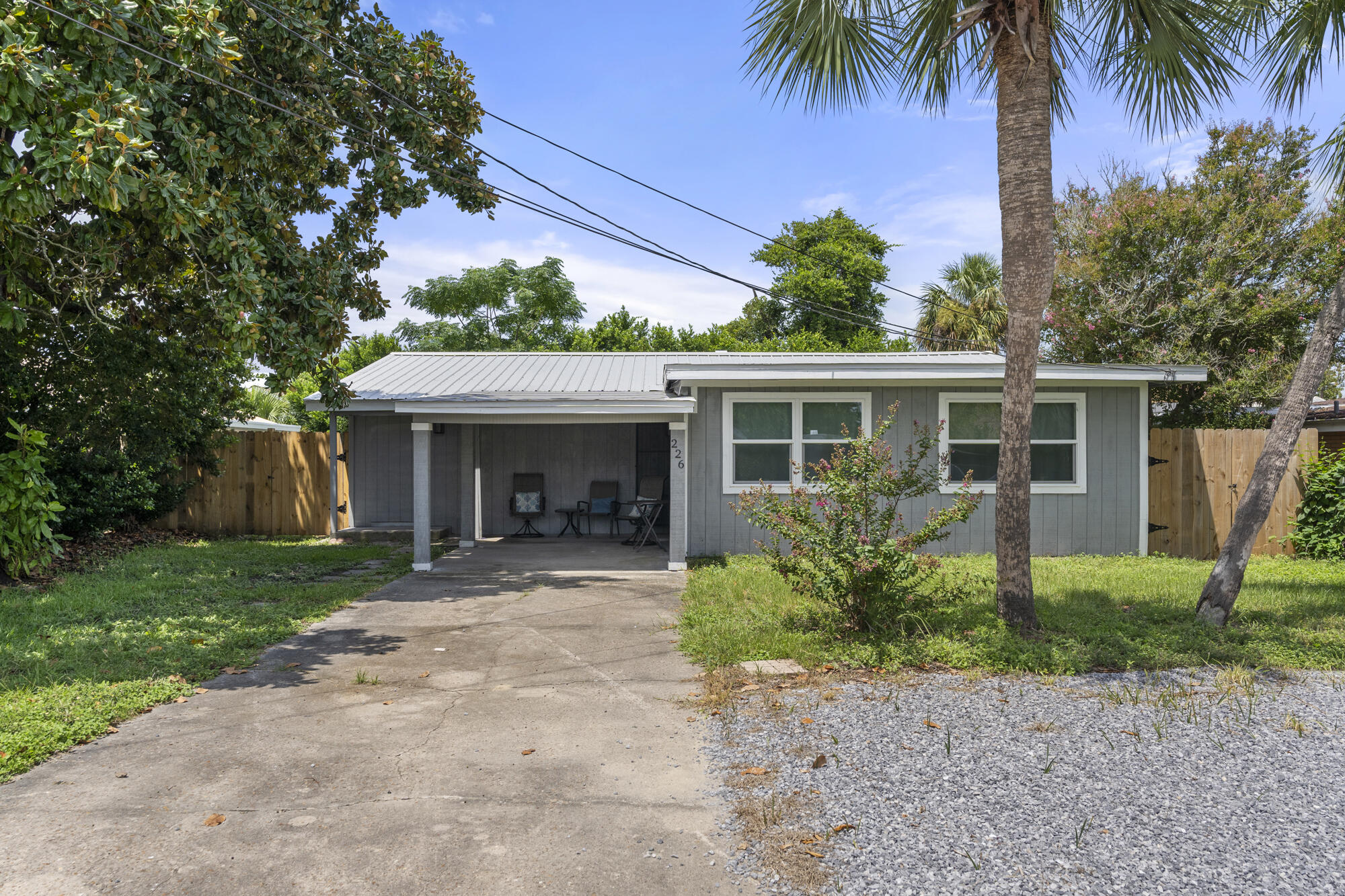 front view of a house with a yard and potted plants