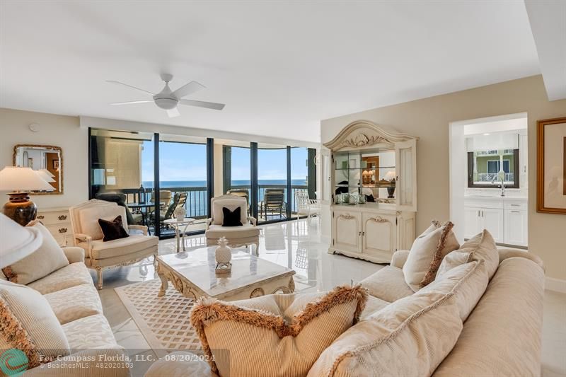 a living room with furniture kitchen view and a large window