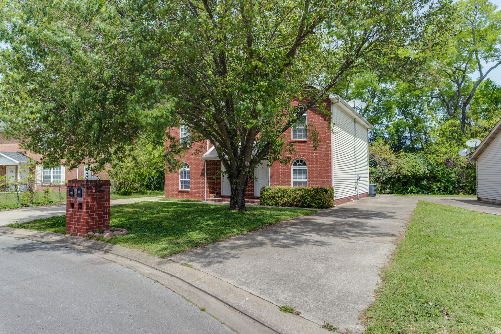 a front view of a house with a garden and trees