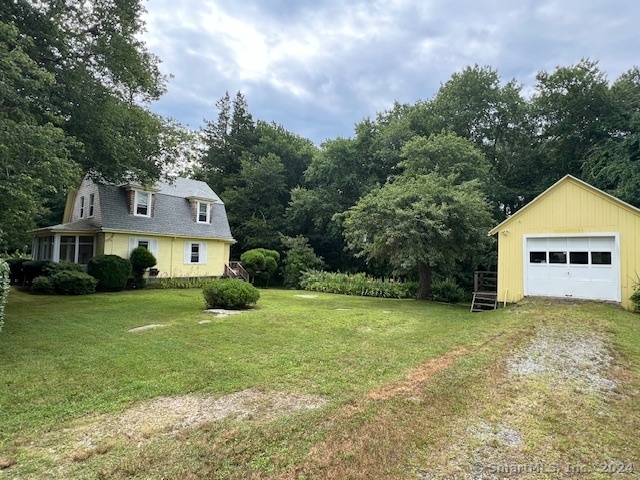 a view of a house with a yard and large trees