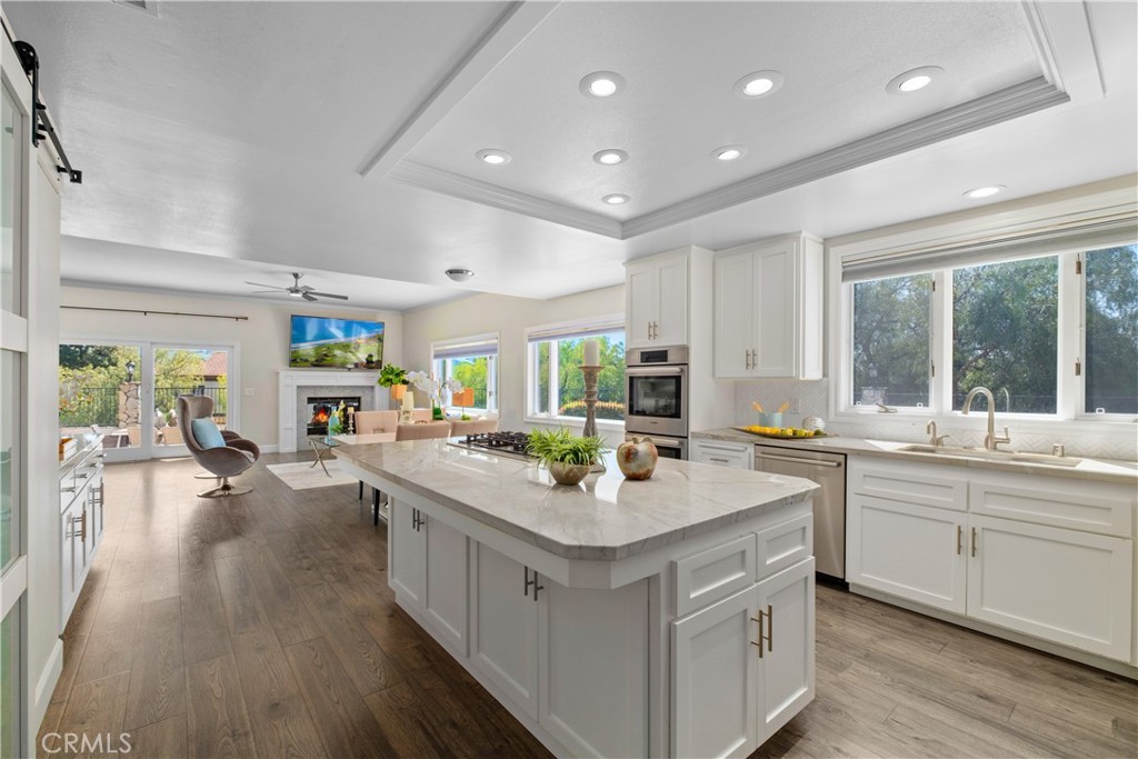 a kitchen with sink stove and wooden floor