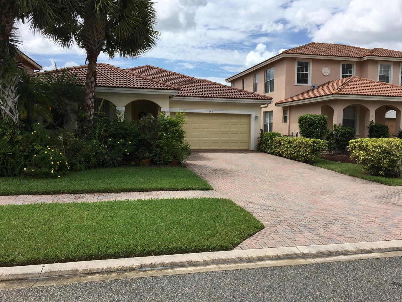 a front view of a house with a garden and yard