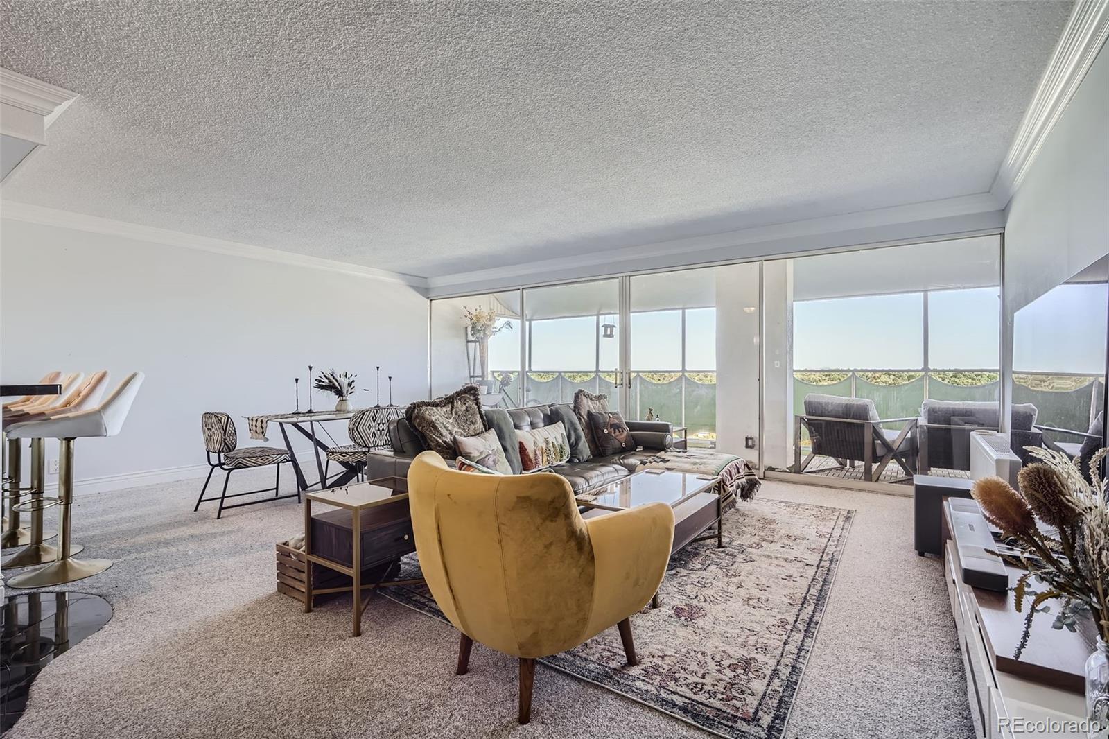 a living room with furniture large windows and a table