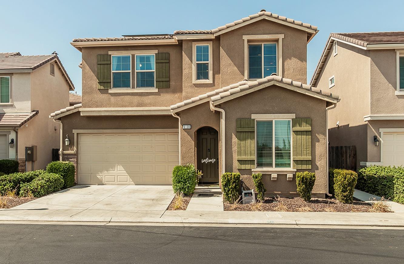 a front view of a house with a yard and a garage