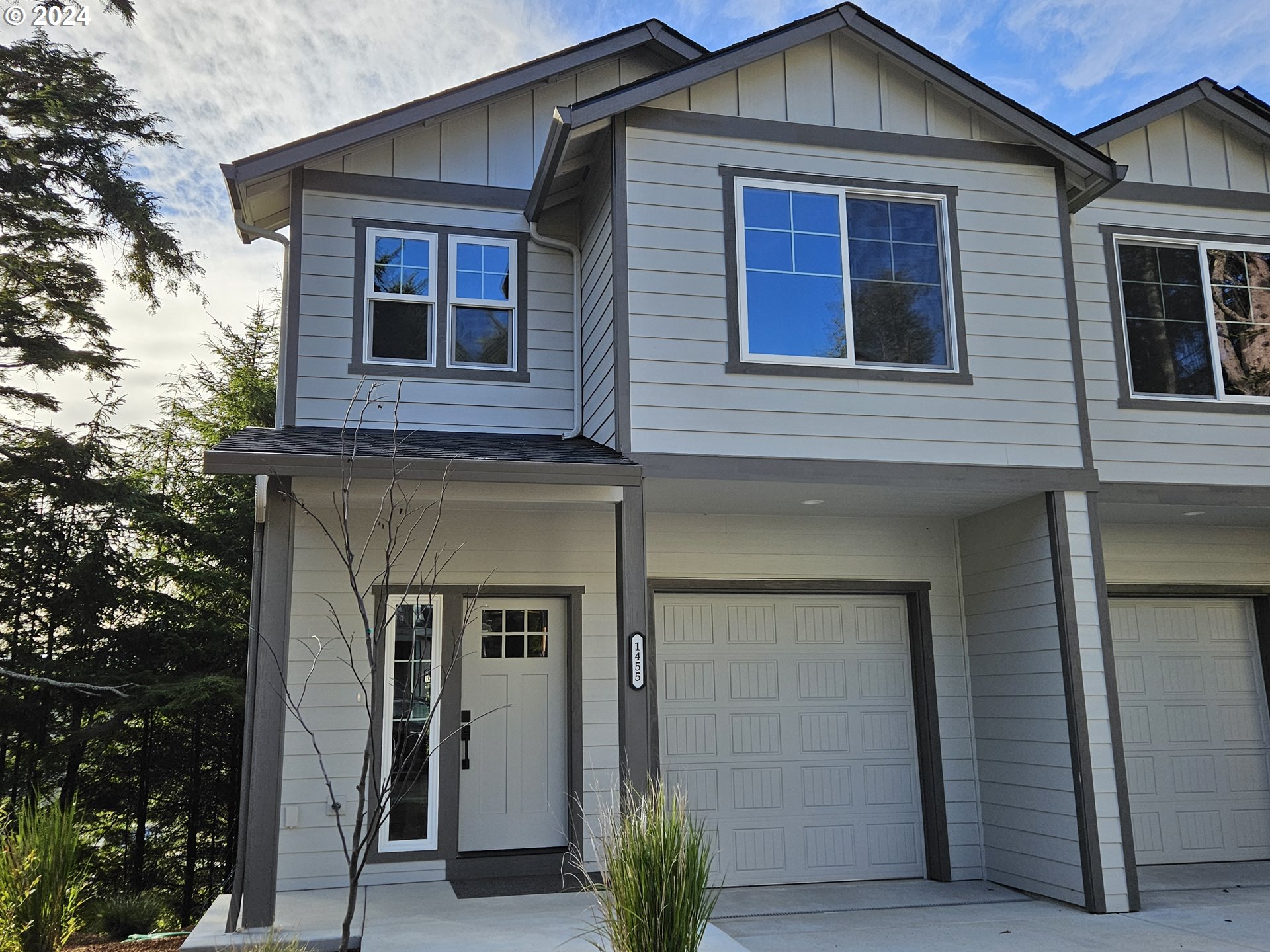 a front view of a house with glass windows and garage