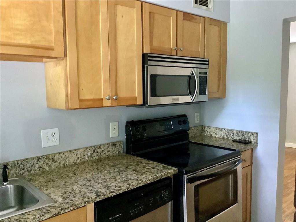 a kitchen with granite countertop a stove sink and microwave