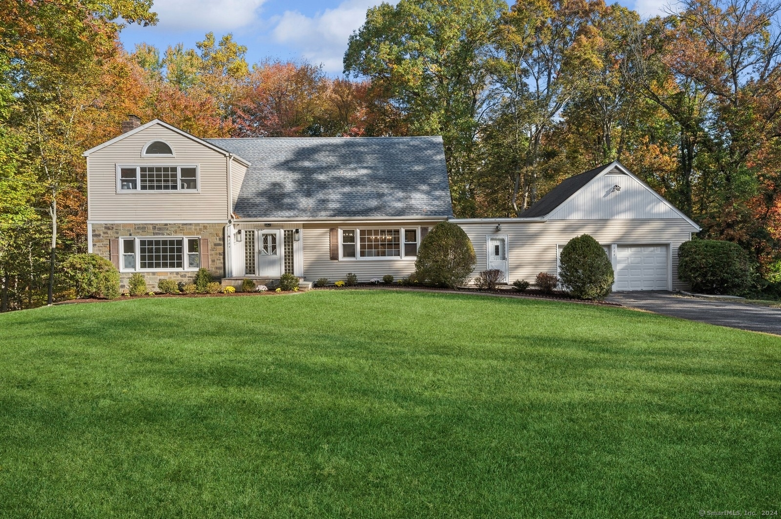 a front view of a house with a yard and trees