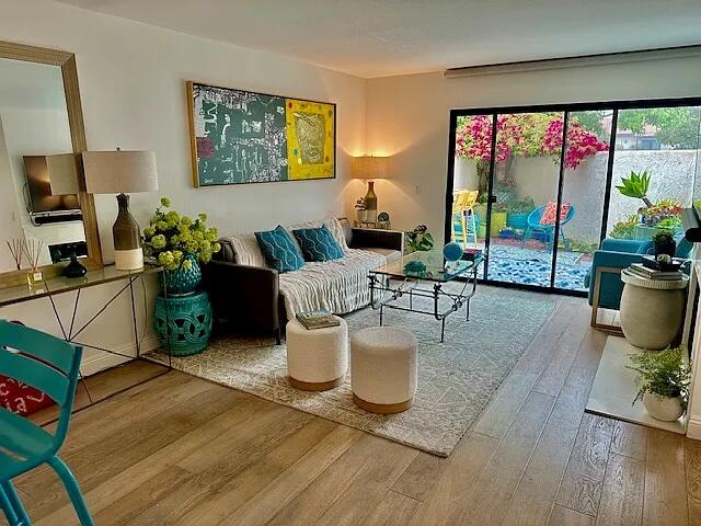 a living room with furniture a flat screen tv and a floor to ceiling window