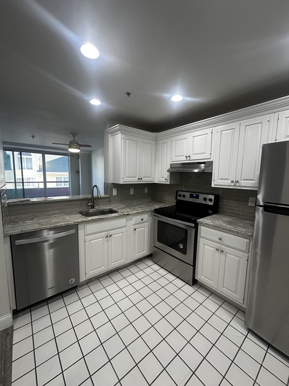 a kitchen with granite countertop cabinets stainless steel appliances and a sink