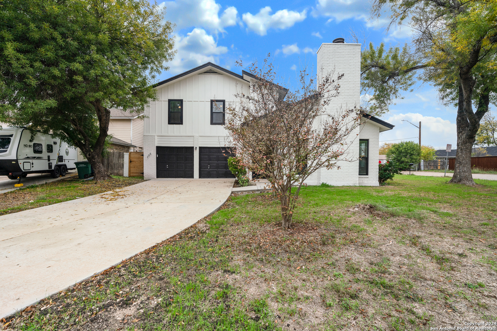 a front view of a house with a yard and trees