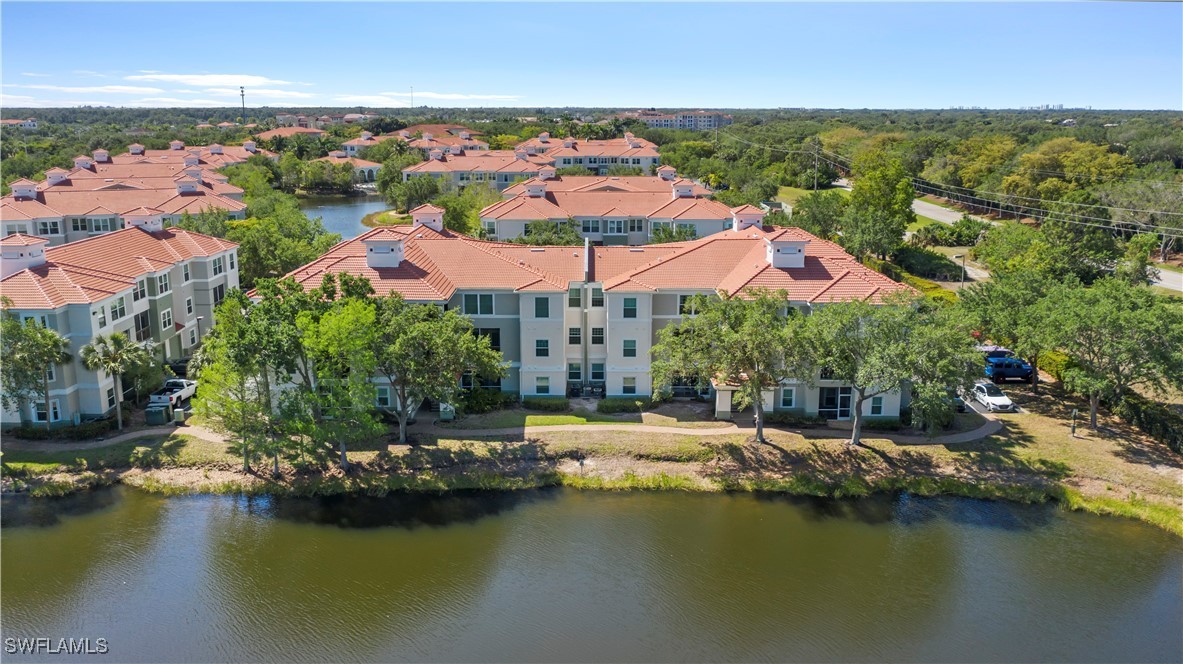 an aerial view of residential houses with outdoor space and lake view