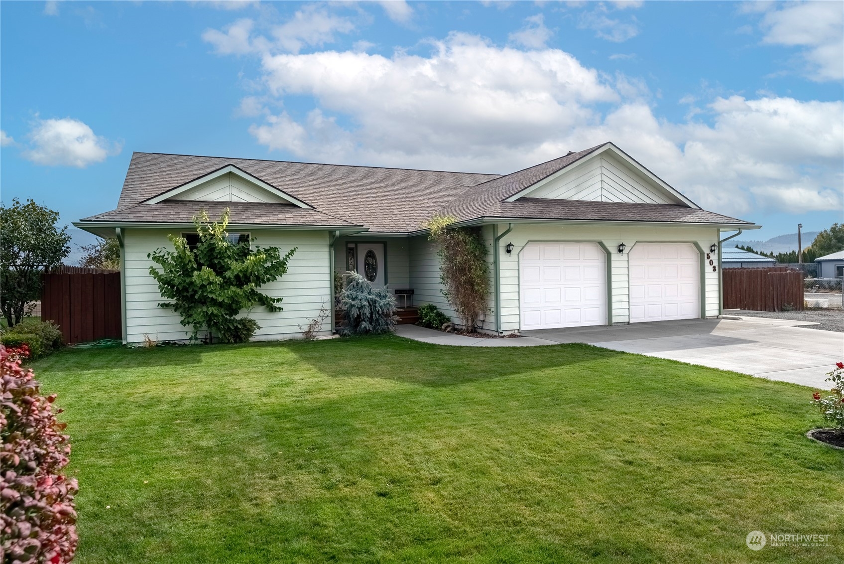 a front view of a house with a garden and yard