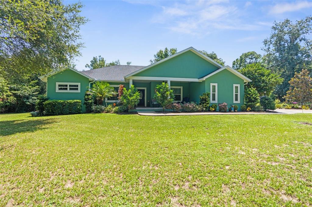 a front view of house with yard and green space