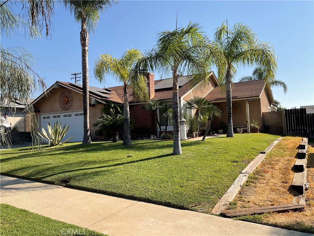 a front view of a house with a garden and trees