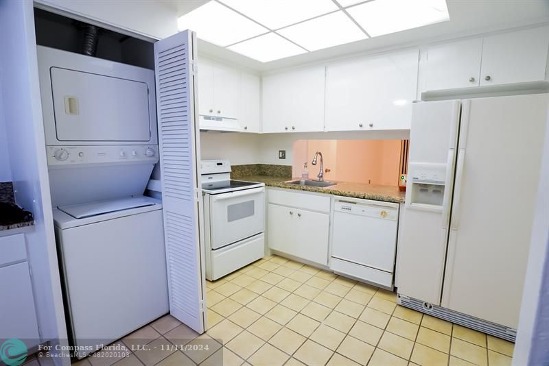 a kitchen with a sink a refrigerator and cabinets