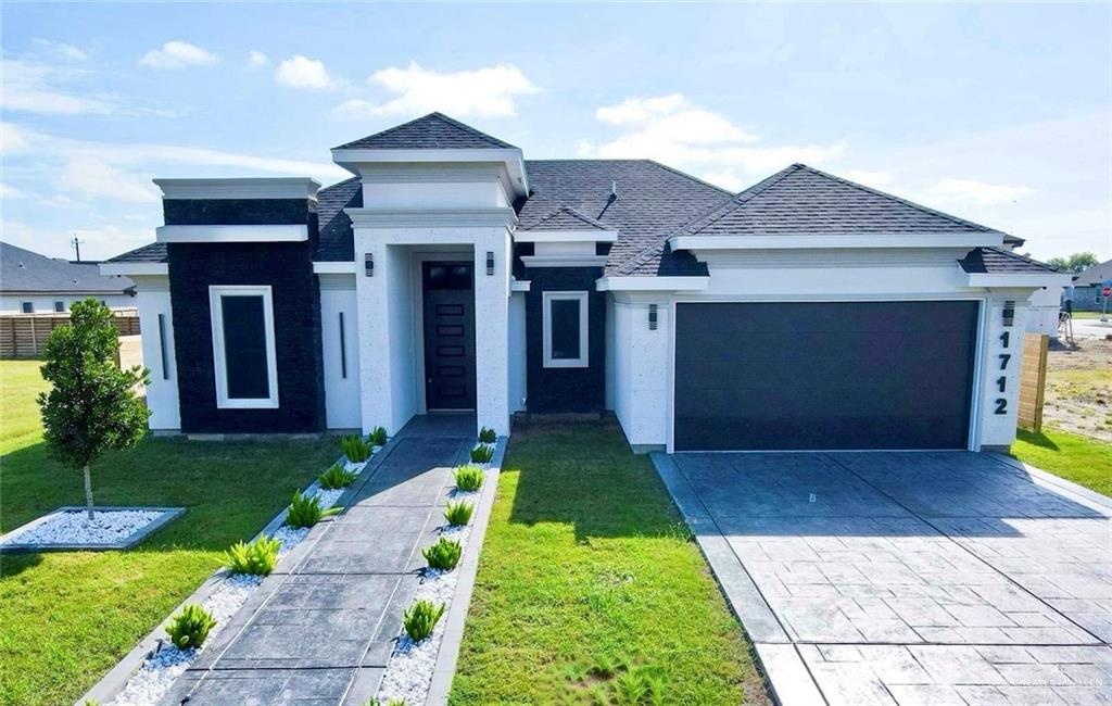 a front view of a house with a yard and garage