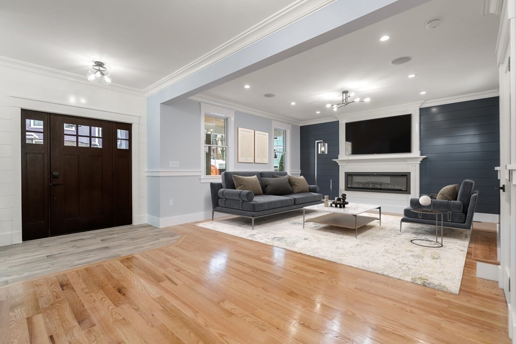 a living room with furniture a flat screen tv and a fireplace