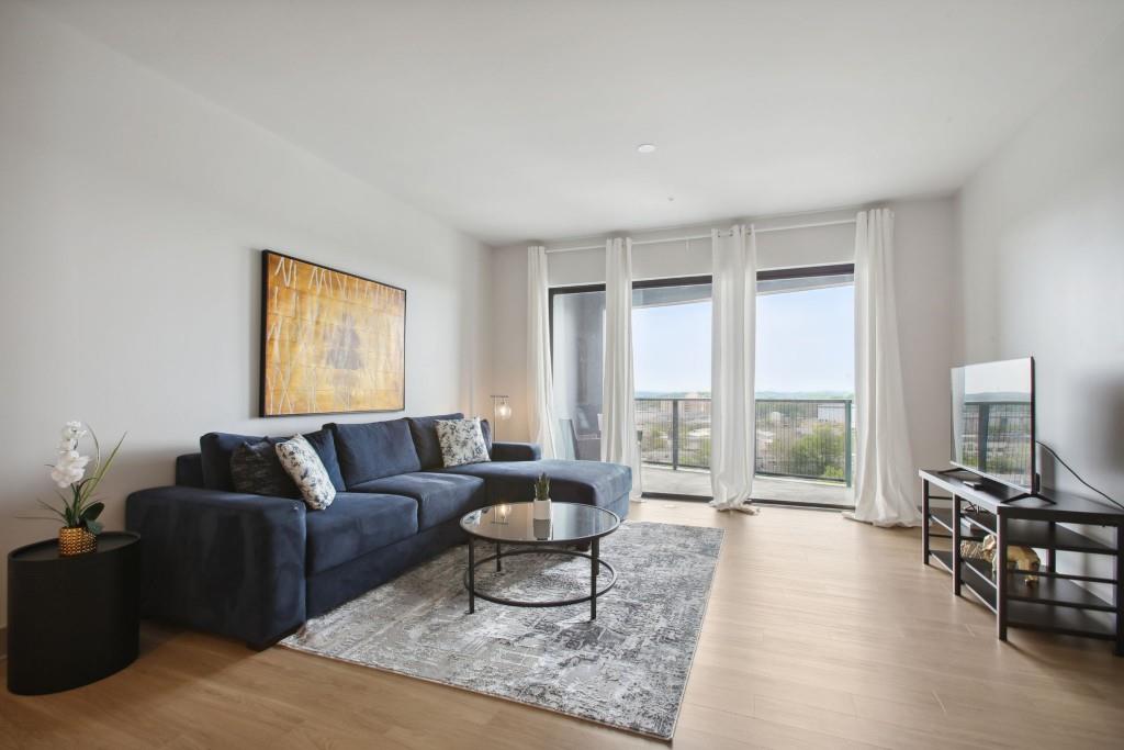 a living room with furniture and a flat screen tv with wooden floor